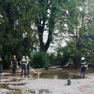 Pioggia battente su Magenta, volontari di Protezione Civile prosciugano le pozze d’acqua attorno alla statua di Mac Mahon