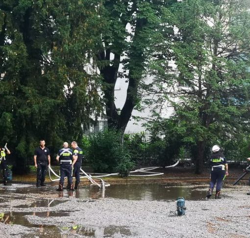 Pioggia battente su Magenta, volontari di Protezione Civile prosciugano le pozze d’acqua attorno alla statua di Mac Mahon