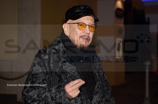 Enrico Ruggeri al suo arrivo mercoledì a Sanremo e, sotto, il post su Facebook