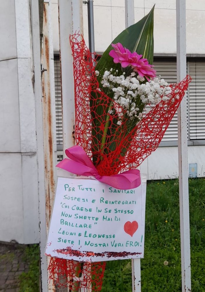 Magenta: &quot;No green pass&quot; depongono un mazzo di fiori sui cancelli del Fornaroli per omaggiare i sanitari prima sospesi e poi reintegrati