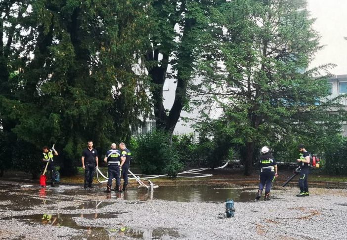 Pioggia battente su Magenta, volontari di Protezione Civile prosciugano le pozze d’acqua attorno alla statua di Mac Mahon